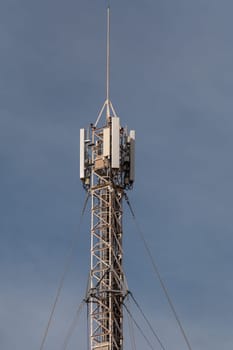 Antenna mast for mobile radio communications in front of a blue sky