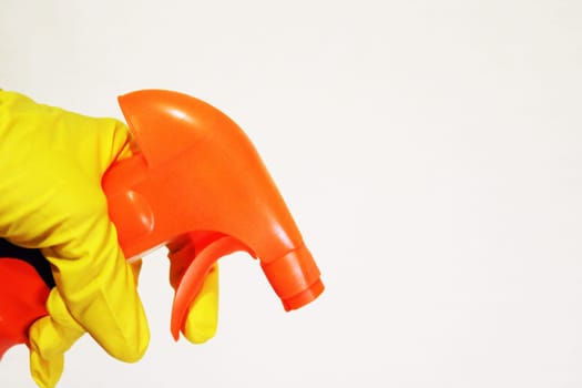 Image of a hand wearing a rubber glove with a cleaning spray. The concept of purity..