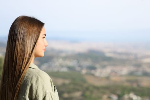 Serious teen contemplating views in city outskirts