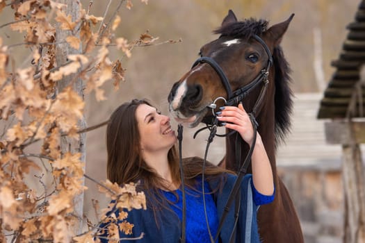 Close-up portrait of a horse and a beautiful girl of Slavic appearance