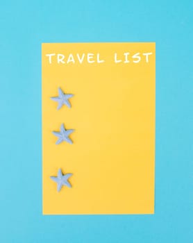 Travel list is standing on the yellow colored paper, sea stars, holiday plan and destination, vacation and lifestyle concept