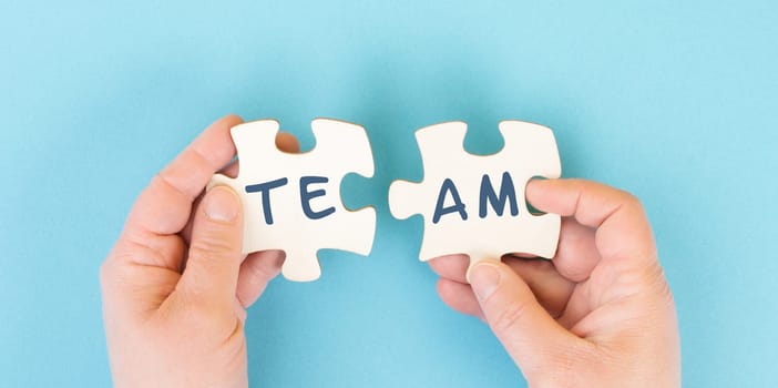 The word team is standing on puzzle pieces, connect the parts together, corporate in teamwork, communication and support concept