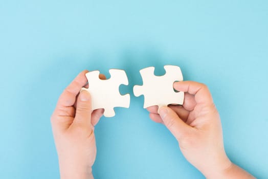 Holding two pieces of a puzzle in the hands, connecting together as a team, solving a problem, strategy and communication concept