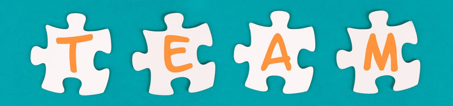 The word team is standing on puzzle pieces, connect the parts together, corporate in teamwork, communication and support concept