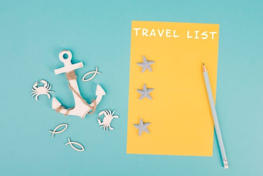 Travel list is standing on the yellow colored paper, anchor with fish sea stars and crabs, holiday plan and destination, vacation and lifestyle concept