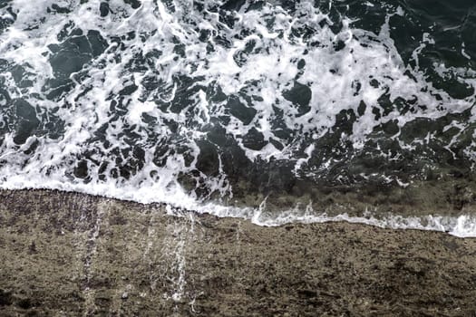 Detail of water waves in the sea, summer day at the beach