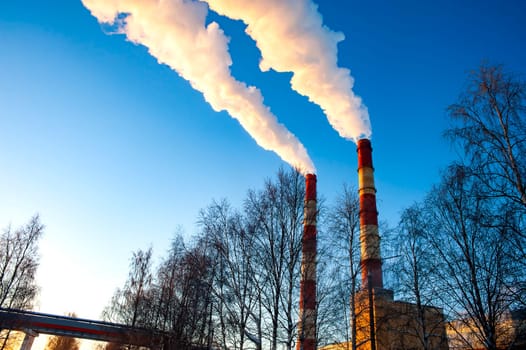 white smoke is coming out of the pipes in the blue sky. High quality photo
