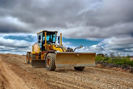 a grader on the construction site levels the rubble. High quality photo