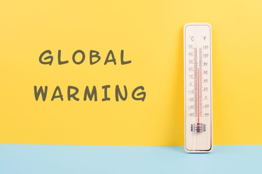 Thermometer on a yellow and blue colored background, measure the temperature, weather forecast, global warming and environment discussion, summer season