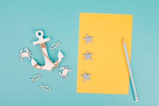 Travel list, yellow colored paper, anchor with fish sea stars and crabs, holiday plan and destination, vacation and lifestyle concept