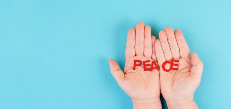 Holding the word peace in the hands, stop war, support Ukraine, living peaceful together