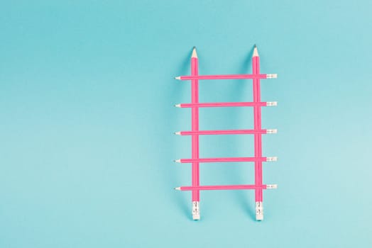 Ladder of success build with pencils, opportunity strategy, blue background, copy space for text, step by step concept, progress in business and education, have a goal