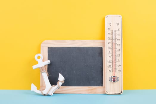 Empty chalkboard with a thermometer and an anchor, holiday background, summer vacation, hot weather, environmental issue