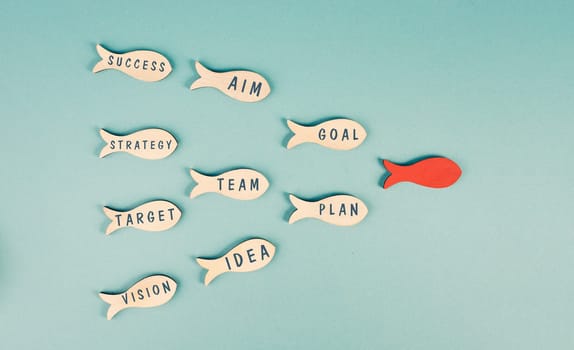 Red fish is the leader of the group, working as a team for new ideas, goals, making plans and strategies for success, teamwork concept