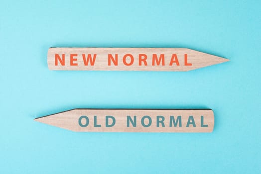The words new and old normal are standing on wooden arrows, transformation of society after pandemic, strategy for the future