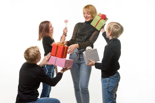Children give a gift to mom, boys give a gift in boxes, flower girl
