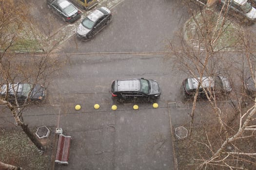 snowfall winter, top view of the road and parked cars