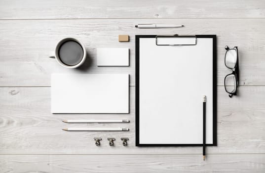Blank corporate stationery set on light wooden background. Brand identity mockup. Flat lay.
