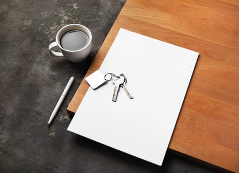 Real estate paperwork concept. Blank letterhead, key, coffee cup and pen.