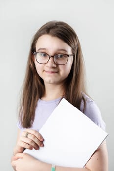 Smiling girl wearing glasses with blank sketchbook. Education concept.