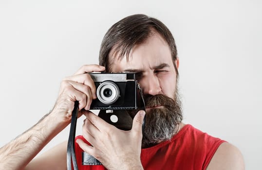 Serious bearded man with camera. Photographer self portrait with vintage photo camera.