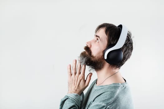 Bearded man wearing headphones listening to music. Enjoy music. Profile view.