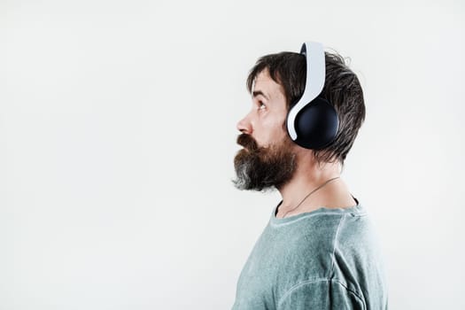 Side view of bearded man listening music in headphones.