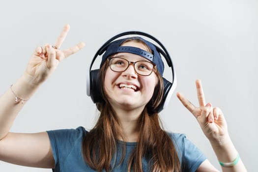 Laughing teen girl listening music in headphones. Child girl enjoying music.