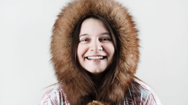 Happy smiling woman in fur hood. Laughing woman in winter fur hat.