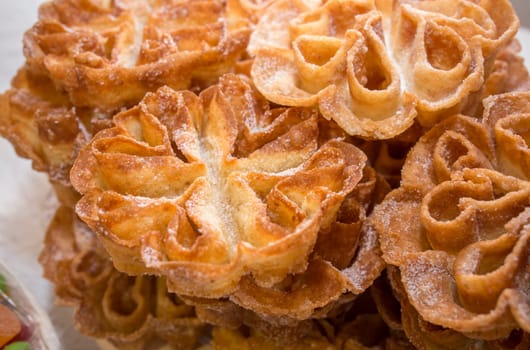 Platter full of traditional fried flores or flowers. Spanish fritter dusted with sugar