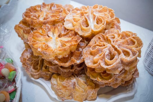 Platter full of traditional fried flores or flowers. Spanish fritter dusted with sugar