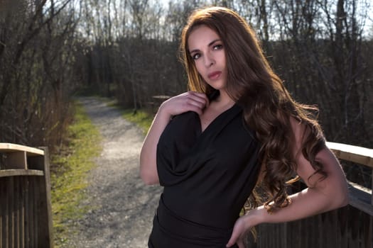 beautiful woman outdoor portrait elegance black dress at the park long hair brunette