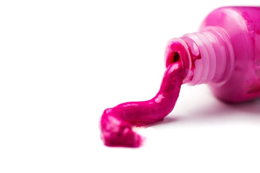 Close-up of an open tube of magenta artist paint spilling out on a white background.