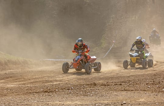 MOHELNICE,  CZECH REPUBLIC - APRIL 16, 2022: Group of quad bike riders in the dust in International Championship of Czech Republic in Sidecarcross, category Quad on April 16, 2022 in Mohelnice.