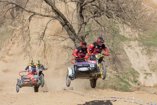 MOHELNICE, CZECH REPUBLIC - APRIL 16, 2022. Two crews of sidecacross motorbike are jumping together in the "Sidecarcross Championship of Czech Republic"" on April 16, 2022 in the town of Mohelnice."