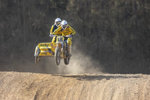 MOHELNICE, CZECH REPUBLIC - APRIL 16, 2022. Sidecacross riders of Herclik team  are jumping with motorbike in the "Sidecarcross Championship of Czech Republic"" on April 16, 2022 in Mohelnice. Czech Republic."