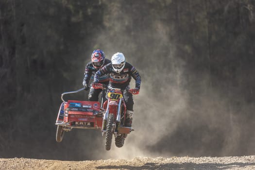 MOHELNICE, CZECH REPUBLIC - APRIL 16, 2022. Riders are jumping with motorbike on dark background in the "Sidecarcross Championship of Czech Republic"" on April 16, 2022 in Mohelnice. Czech Republic."
