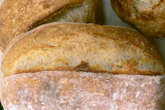 Bread close-up. Freshly baked sourdough bread with a golden crust  . Concept bakery , texture sourdough bread