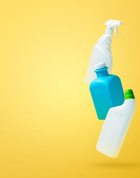 Levitation, falling in air blank household chemical bottles for cleaning the house. Isolated on yellow background. Plastic packaging. Toilet cleaner, detergent sprayer, soap. New brand product mockup