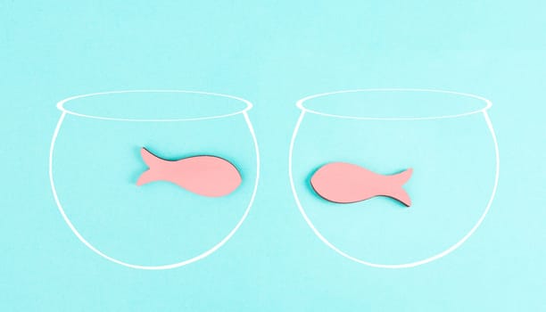 Two little fish in separated aquariums looking at each other, freedom and friendship concept, having a meeting and conversation, problem solving, helping