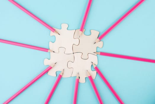Working as a team, puzzle pieces connect together, pencils point to the jigsaw, brainstorming for ideas, business and education concept