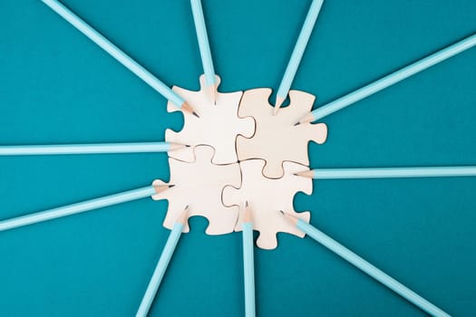 Working as a team, puzzle pieces connect together, pencils point to the jigsaw, brainstorming for ideas, business and education concept