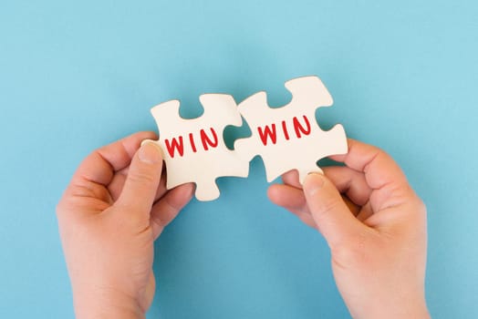 The word win is standing on puzzle parts, problem solving, winner mindset, business and education concept, coaching and motivation