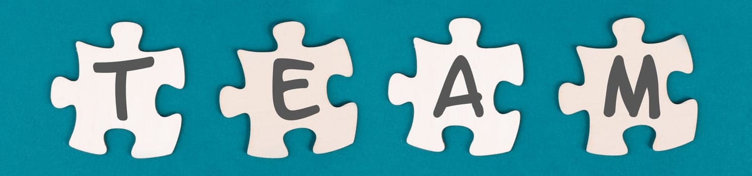 The word team is standing on puzzle pieces, connect the parts together, corporate in teamwork, communication and support concept