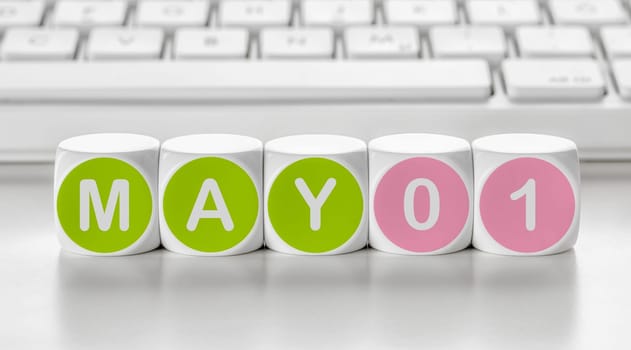Letter dice in front of a keyboard - May 01