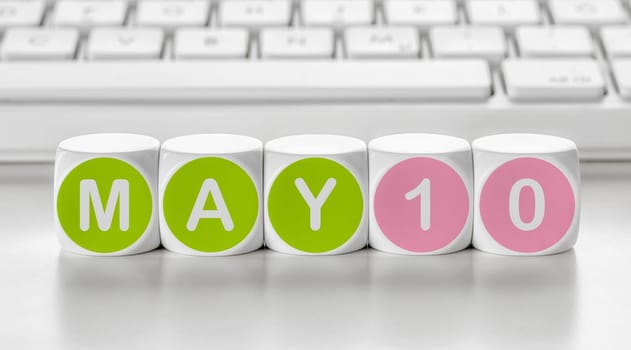 Letter dice in front of a keyboard - May 10