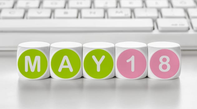 Letter dice in front of a keyboard - May 18