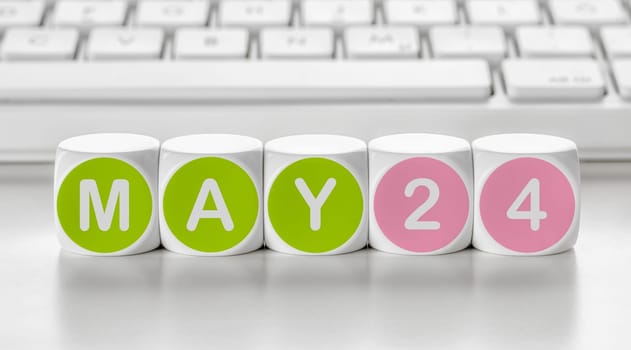 Letter dice in front of a keyboard - May 24