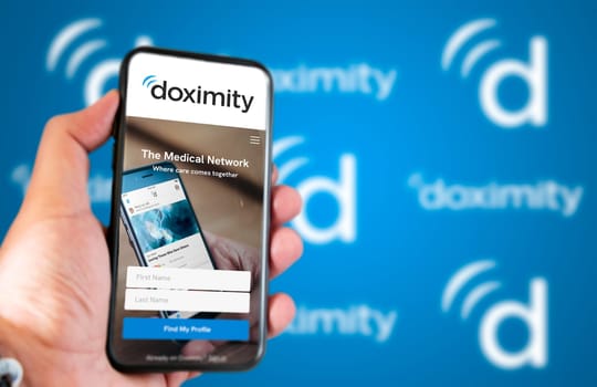 San Francisco, CA, USA March 2022: Doximity company website on a phone screen. Blue background with Doximity logo blurred in the background. Illustrative editorial. Selective focus.