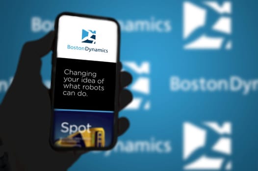 Waltham, MA, USA March 2022: Boston Dynamics company’s website on a phone screen. Blue background with Boston Dynamics logo blurred in the background. Illustrative editorial. Selective focus.